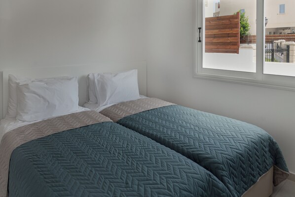 A bed with two pillows and two teal bedspreads. - Phaedrus Living Olga Residence (Paphos)