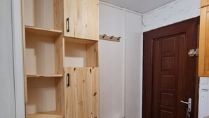 A room with a wooden wardrobe, a white door, and a wooden floor. - Studio Cozy in Pyrénées 2000 (Bolquère)