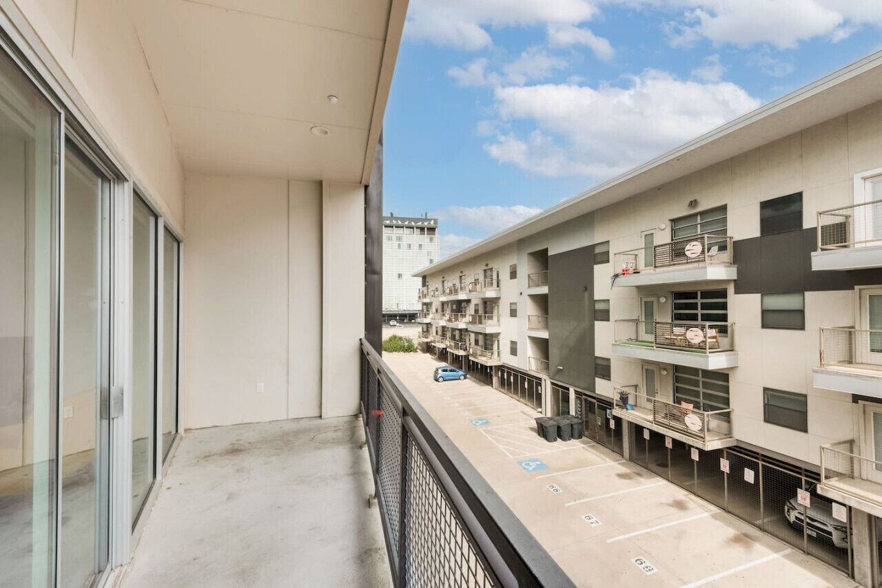 A multi-story residential building with a parking area in front.