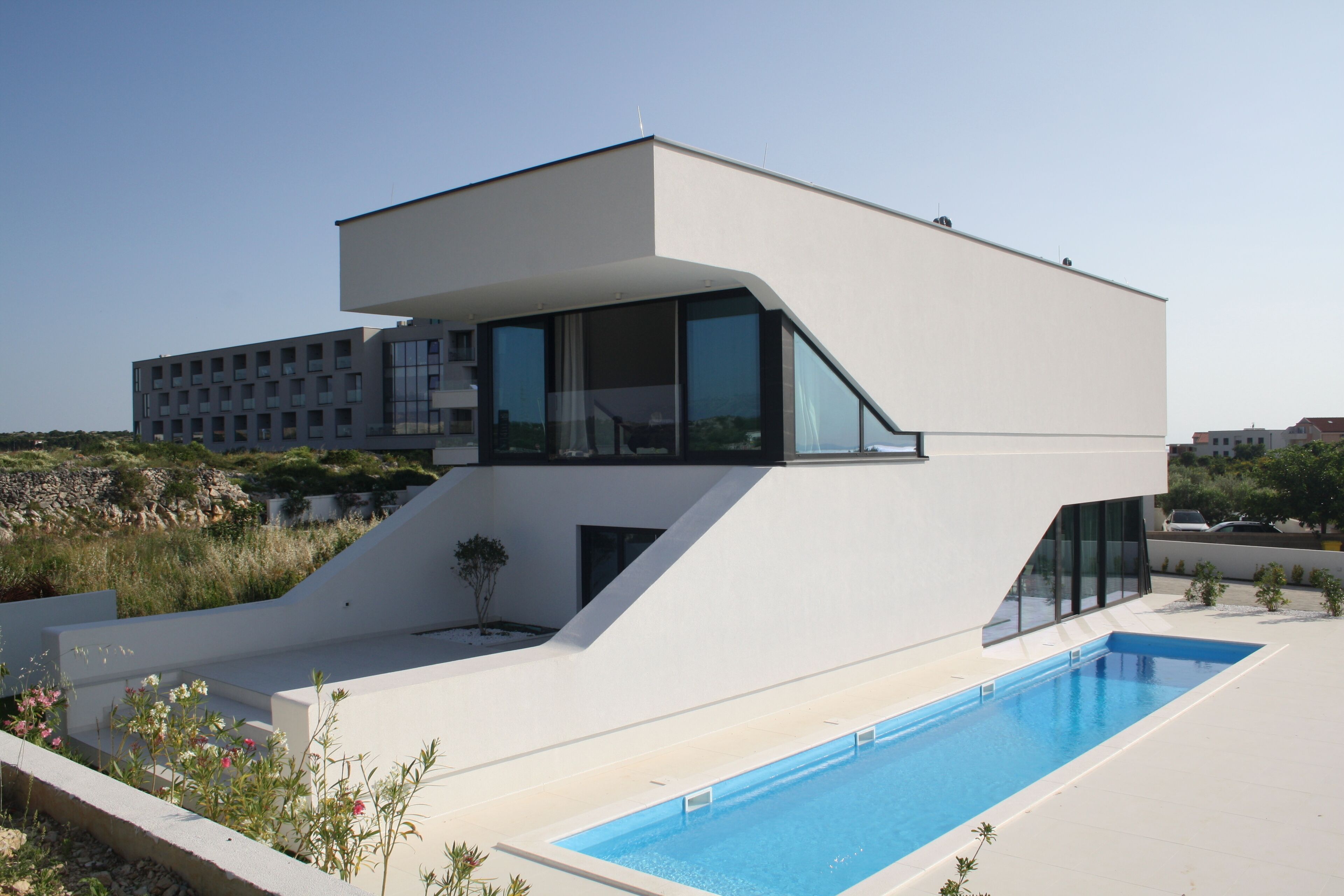 A modern two-story house with a swimming pool.