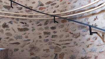 A staircase with stone walls and metal handrails, leading to an upper level.