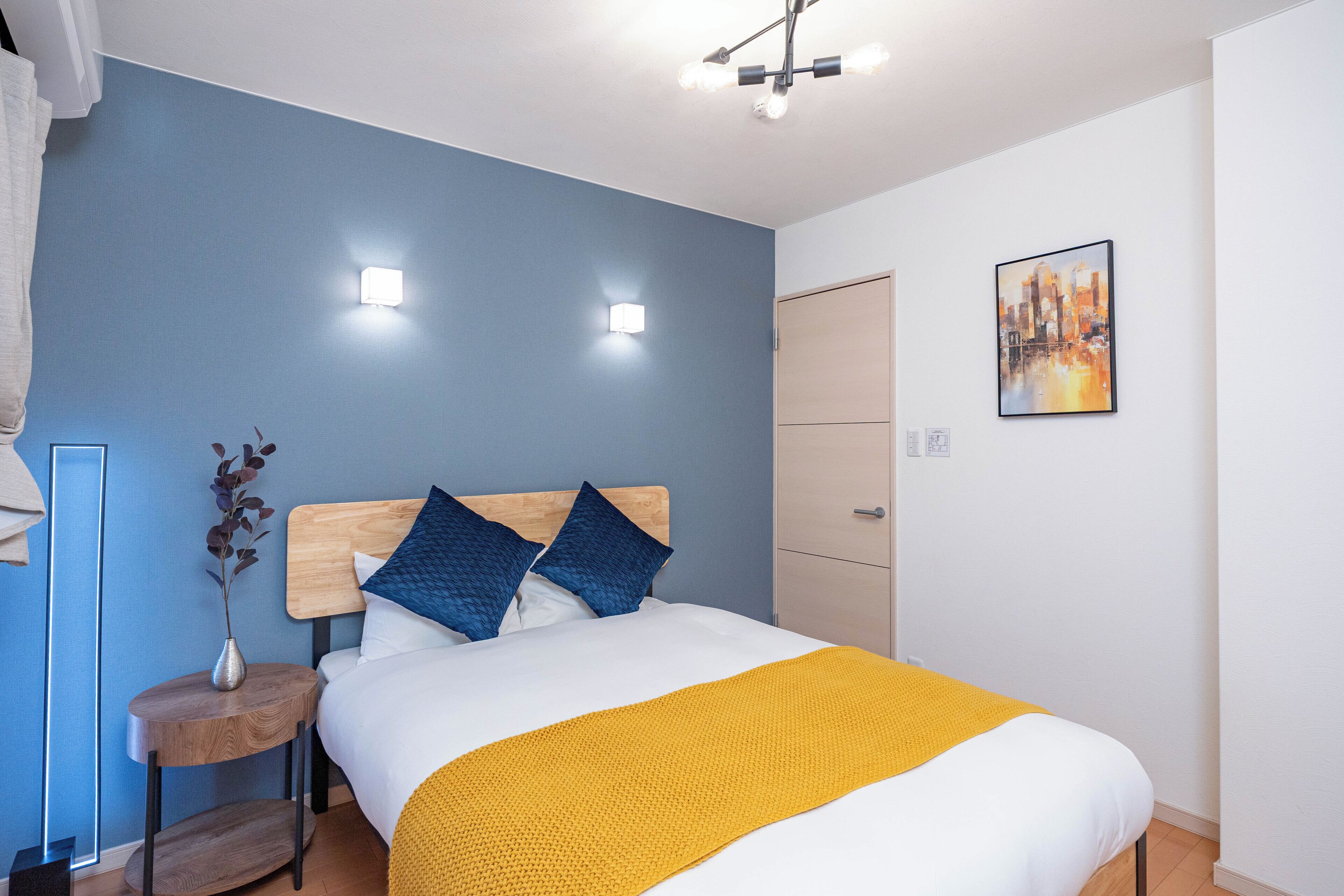 Ein Schlafzimmer mit einem Bett, einem Nachttisch und einer Wandleuchte.