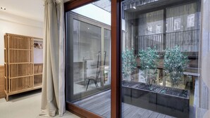 Un intérieur moderne avec une porte-fenêtre coulissante donnant sur un balcon agrémenté de plantes en pot.