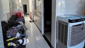A hallway with a laundry basket filled with clothes, a standing fan, and a door leading to another room. - Imperia Sky Garden Dream Loft (Hanoi)