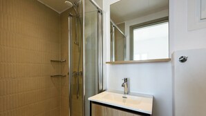 A modern bathroom with a glass-enclosed shower, a white sink, and a large mirror above the sink. - Phaedrus Living: Paros Cycladic Residences 7 (Piso Livadi)