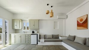 Une cuisine moderne avec des meubles blancs, un réfrigérateur encastré et un sol en pierre.