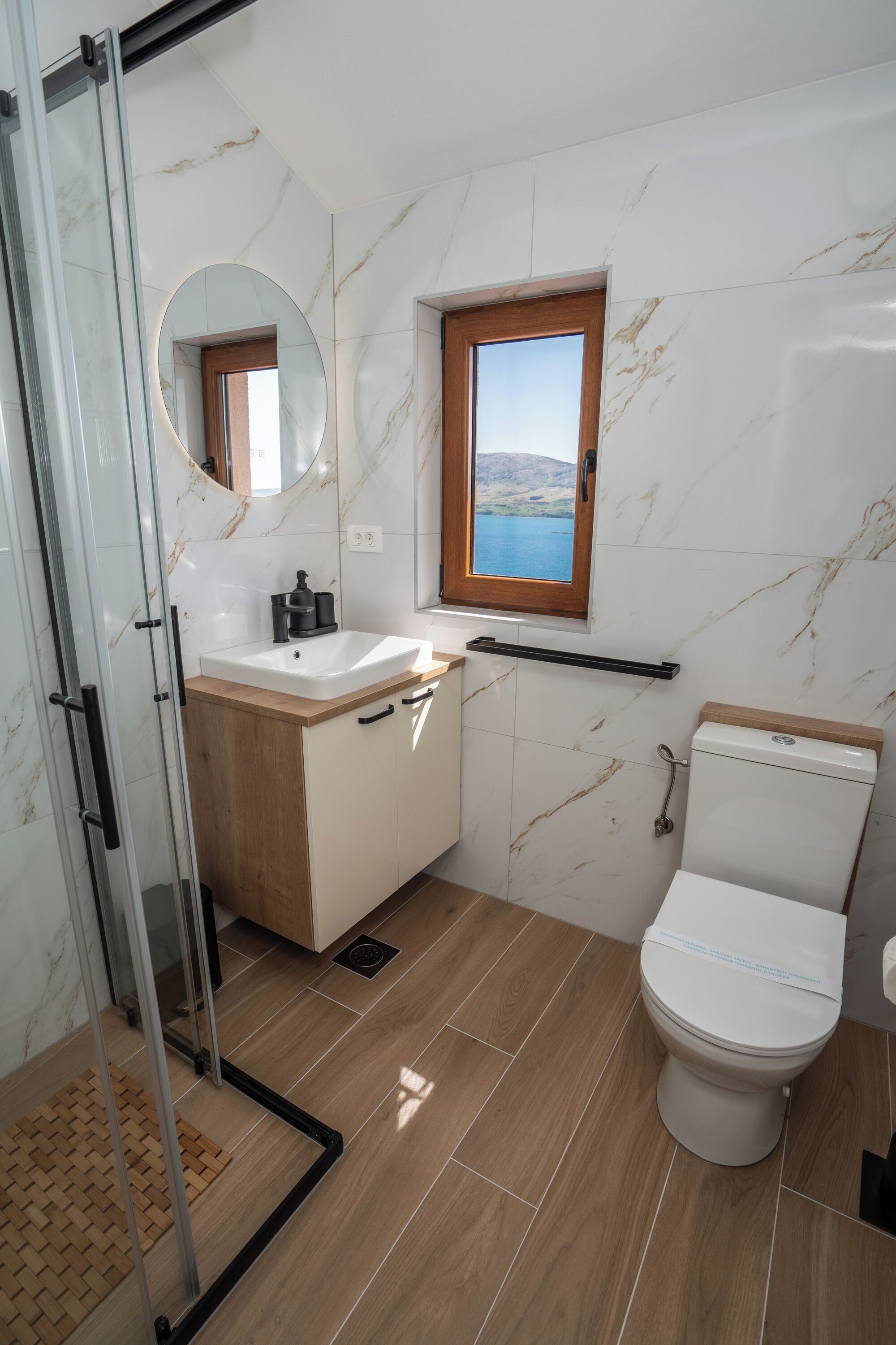 Une salle de bain comprenant des toilettes, un lavabo et un espace douche.