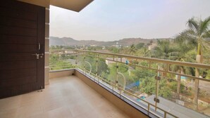 Un balcón con vista a un paisaje verde y colinas lejanas.