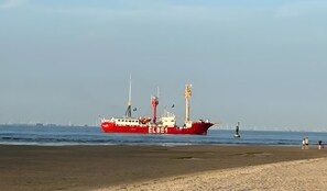 A red ship with the identifier EL 864 on a beach with a clear sky. - Apartment 'Lortz' with Private Terrace, Shared Garden and Wi-Fi (Cuxhaven)