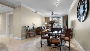 A dining area with a round table, chairs, and a ceiling fan. - Two Bedroom with Pool Views (Destin)