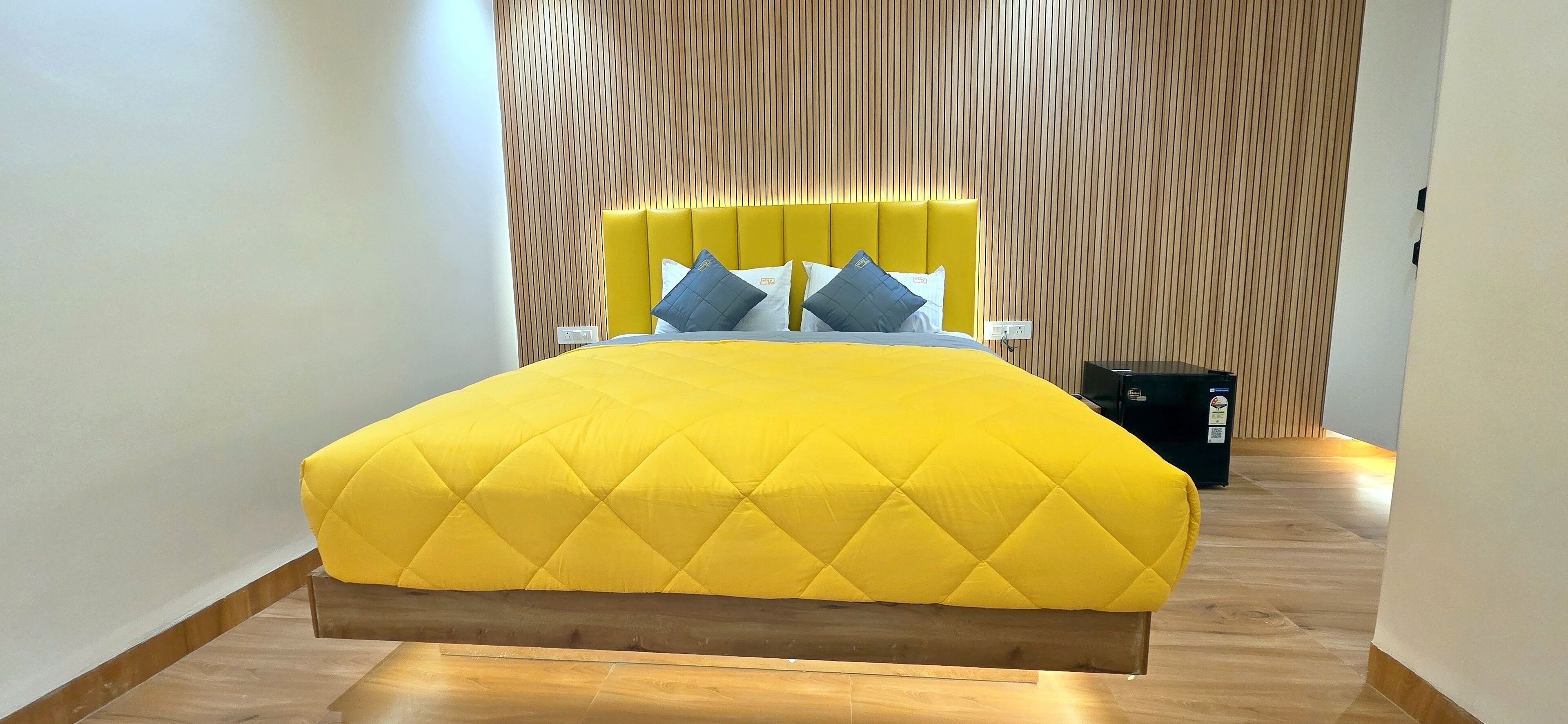 Un dormitorio moderno con una cama grande, un cabecero de madera y un estampado a rayas en la pared.
