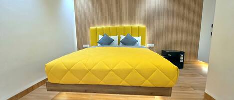 Un dormitorio moderno con una cama grande, un cabecero de madera y un estampado a rayas en la pared.