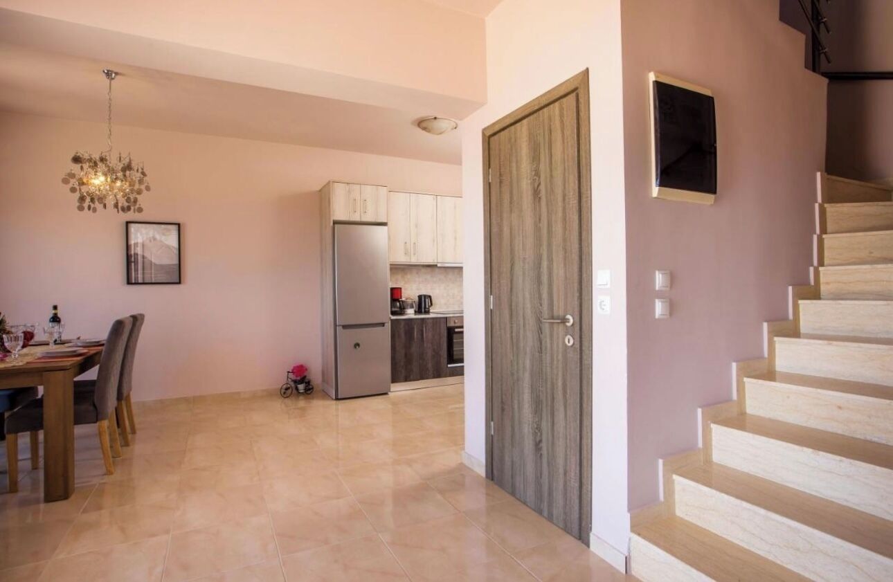 Una cocina moderna con refrigerador, armarios y un comedor con mesa y sillas.