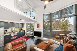 A modern apartment with a kitchen, living area, and balcony. - Cremorne- GA102 Macpherson St - Chic Loft-Style 1BR Apartment with Balcony Rooftop in Heart of Cremorne (Cremorne)