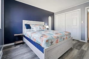 A bedroom with a bed, nightstand, and wardrobe.