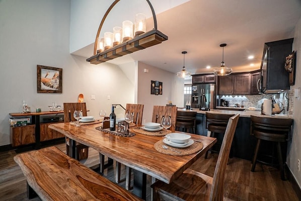 A dining area with a wooden table, chairs, and a chandelier.