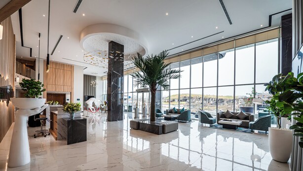 A spacious lobby with a high ceiling, large windows, and a central seating area. - Rhenium Hotel - Abha (Abha)