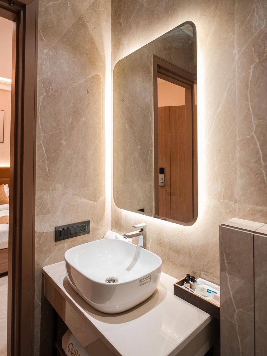 Une salle de bain avec un grand lavabo ovale, un miroir et une porte en bois.