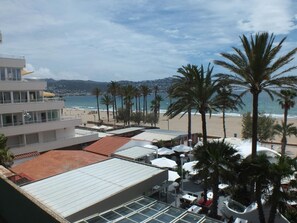 A hotel with a beach view, palm trees, and a coastal landscape. - Apartment in Roses: Terrace, Pool, 6 People (Roses)