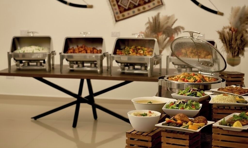 Un buffet proposant une variété de plats et une table dotée d’un cadre en métal noir.
