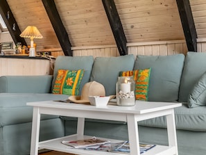 A cozy room with a light blue sofa, a white coffee table, and a lamp.