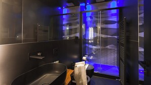 A modern bathroom with a black bathtub, a glass shower enclosure, and a visible towel rack. - MICELI EXCLUSIVE SUITE (Palermo)