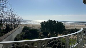 Ein Balkon mit Blick auf Strand und Meer.
