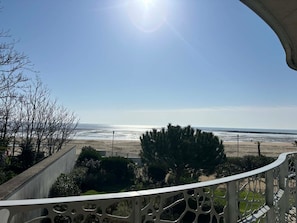 Un balcon avec vue sur la plage et l’océan.