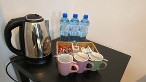 A kitchen counter with a kettle, water bottles, and a tray of food items. - Hostel Uno (Kraków)