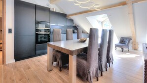 Una cocina moderna con armarios oscuros y una mesa de comedor de madera.