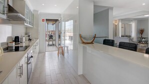 Una cocina moderna con una isla central, electrodomésticos de acero inoxidable y vistas al exterior.