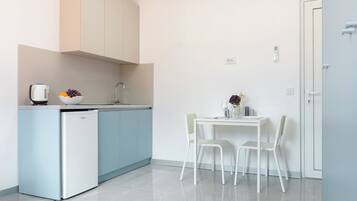 Eine moderne Küche mit integriertem Kühlschrank, Spüle und einem Essbereich mit Tisch und Stühlen.