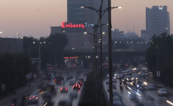 A busy urban street with a prominent building labeled "Embassy" in the background. - Embassy Inn (Karachi)