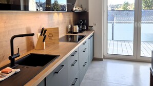Une cuisine moderne avec un plan de travail en bois, un évier et une machine à café.