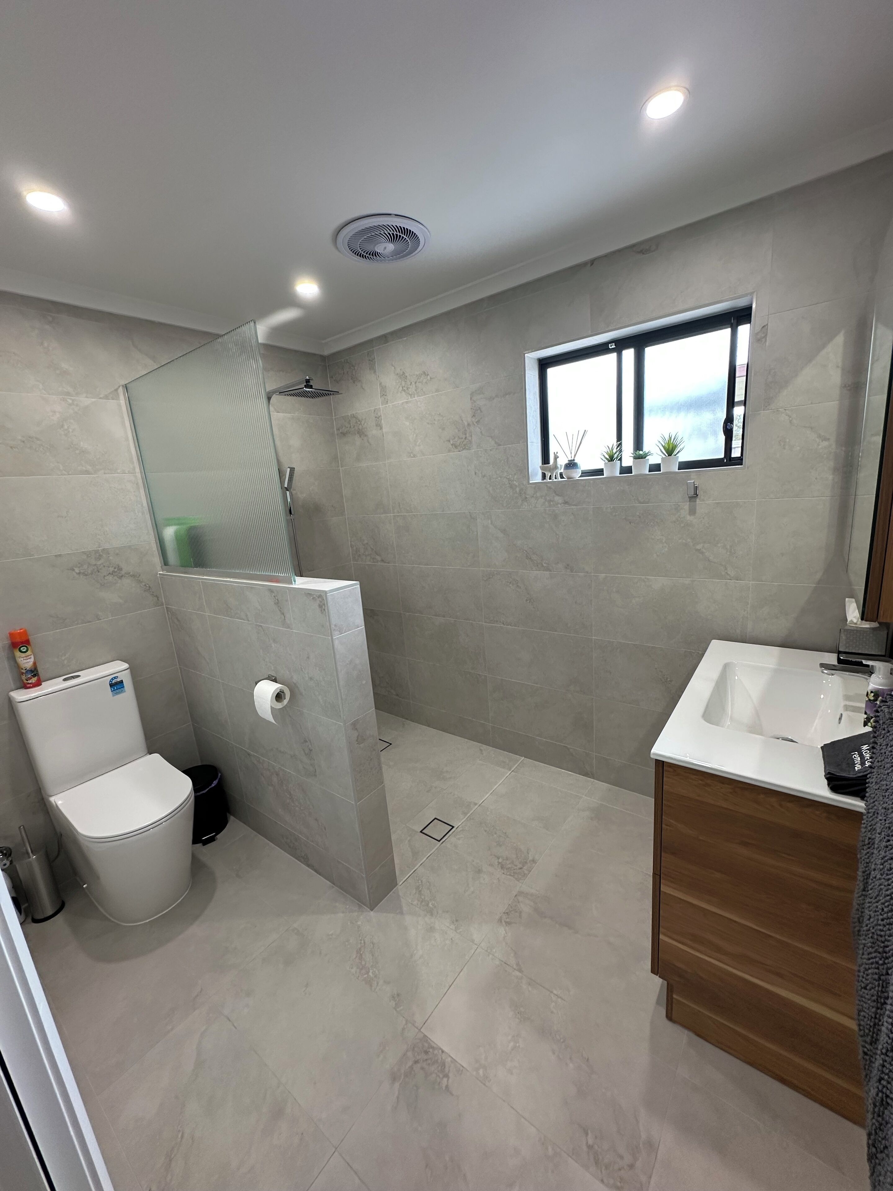 Un bagno moderno con doccia, servizi igienici e lavandino.