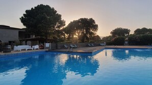 A swimming pool with lounge chairs and a pergola.