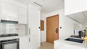 Una cucina moderna con mobili bianchi, forno integrato e piano cottura.