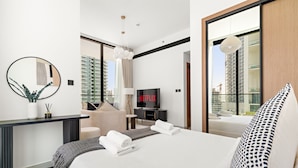 Una camera d'albergo moderna con un letto grande, una televisione, una scrivania e vista sulla città.
