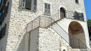 Un edificio de piedra con una escalera que conduce a un balcón.