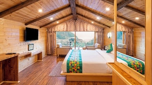 Un dormitorio de cabaña de madera con cama, zona de estar y televisión.