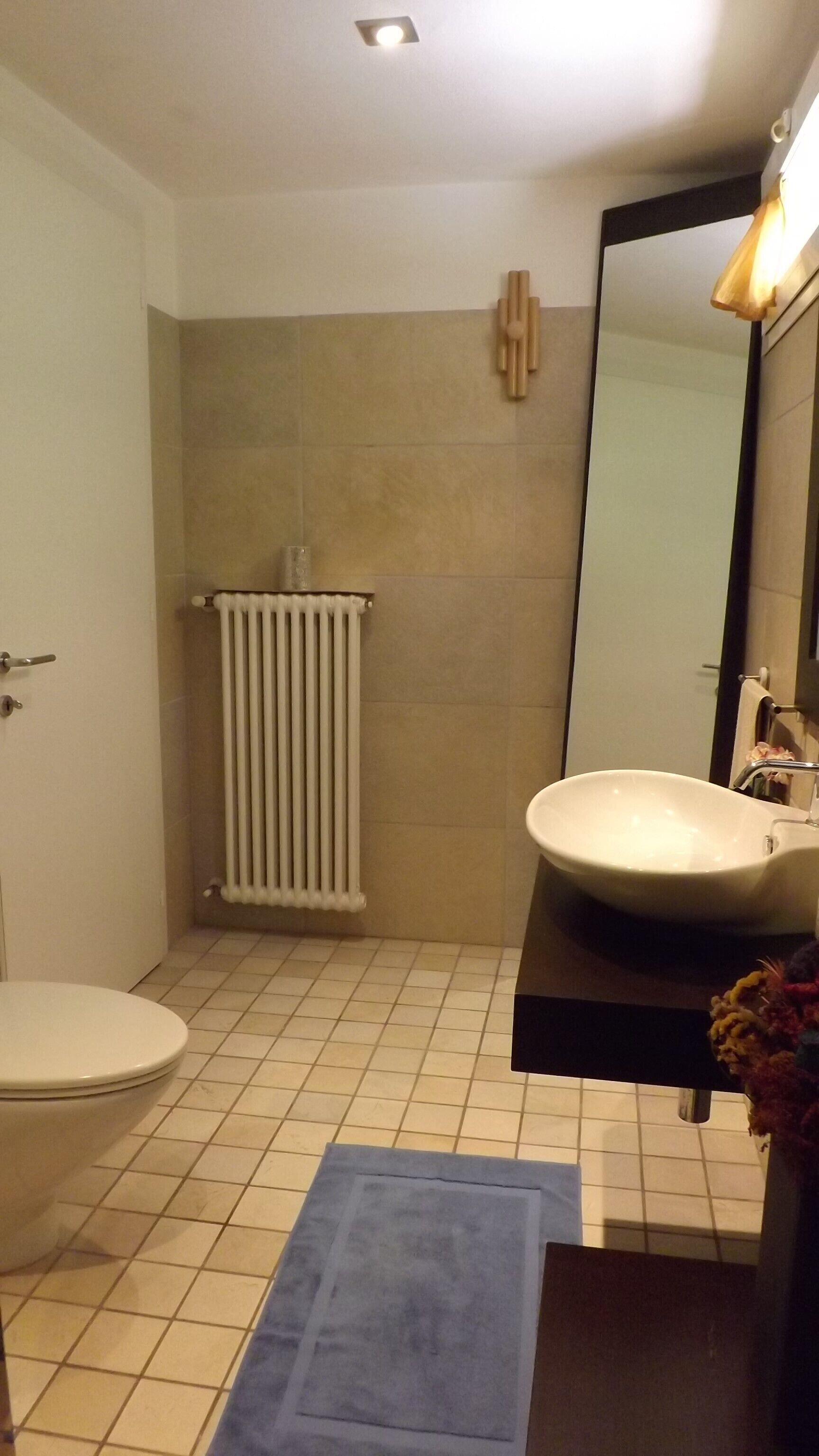 Ein Badezimmer mit Toilette, Waschbecken und Spiegel.