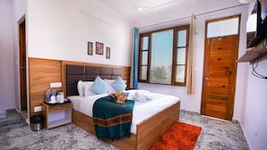 Een hotelkamer met een bed, nachtkastje, raam en een deur.