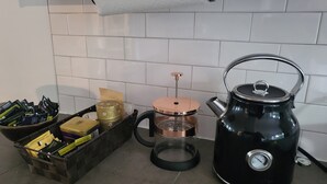 A kitchen with a black kettle, a coffee maker, and a basket of tea bags. - Superb apartment with terrace near metro rosemont (Montréal)