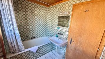 Une salle de bain avec une baignoire, un lavabo et des carreaux décorés.