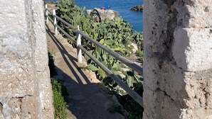 An ancient stone structure with a view of the sea.