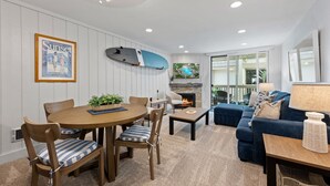 Ein Wohnzimmer mit Essbereich, Kamin und Blick auf einen Pool.