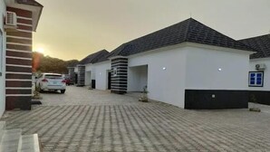 Et boligområde med en asfalteret indkørsel og flere huse med ensartet arkitektur.