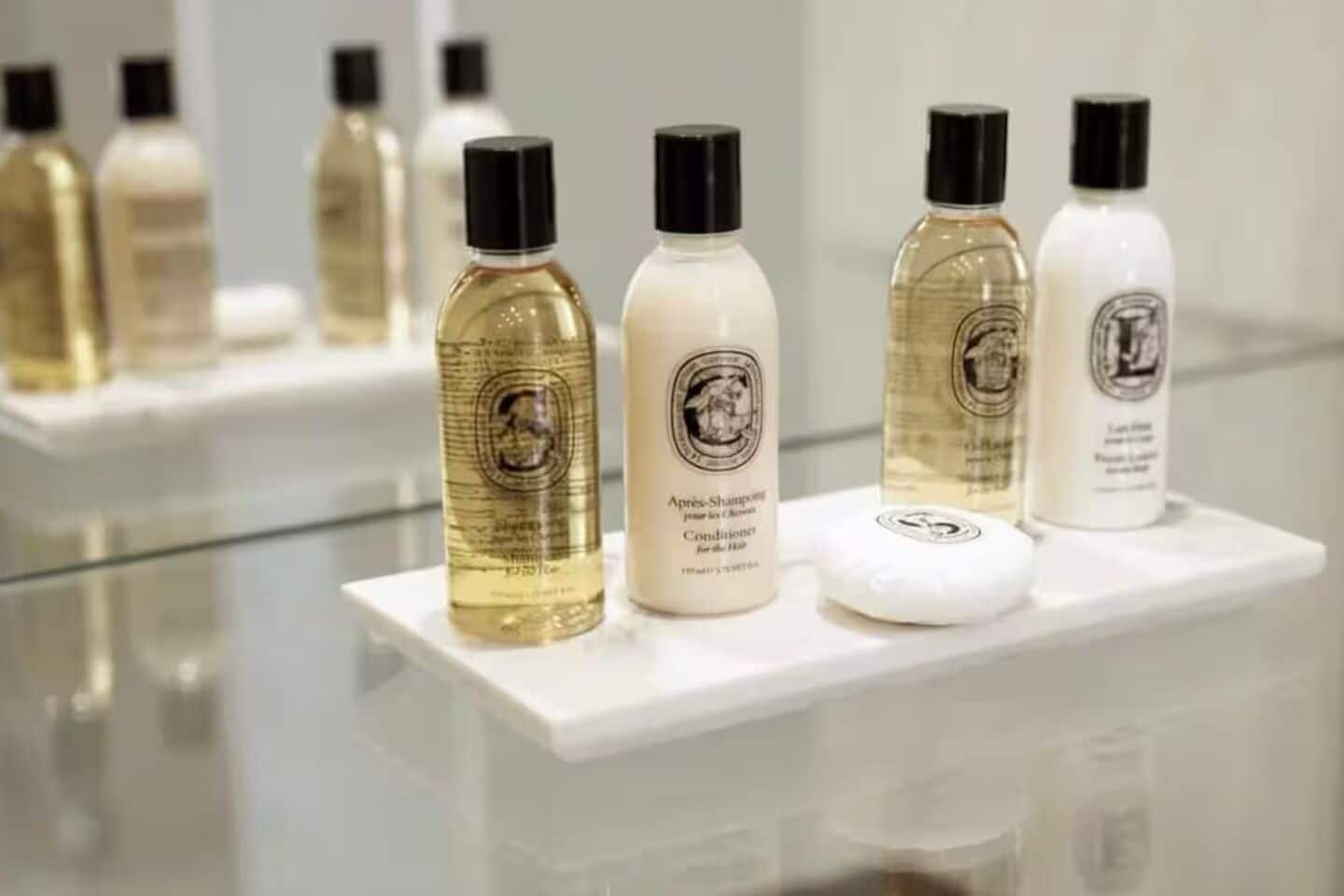 Una exhibición de productos para el cuidado del cabello sobre un estante blanco.