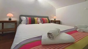 A hotel room with a large bed, two bedside lamps, and a ceiling light. - Palazzo Lomellini Historic Retreat (Genova)