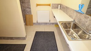 Moderni kylpyhuone, jossa on valkoinen pesuallas, peili, pyyhekoukku ja patteri.